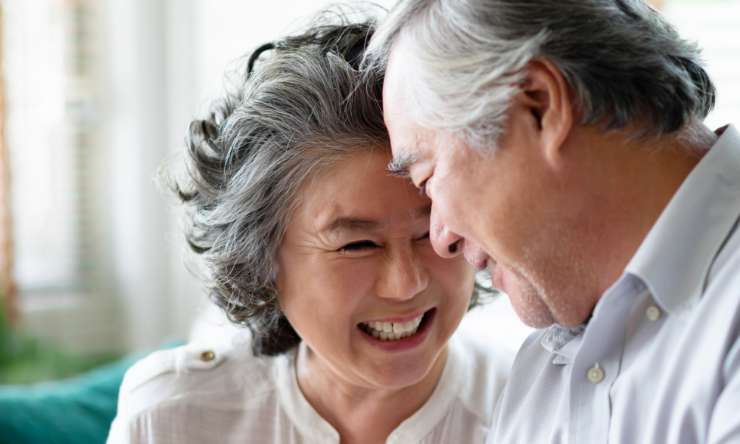 Older couple smiling at each other warmly.