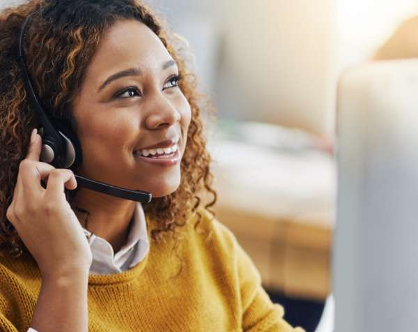Woman wearing a headset, smiling.